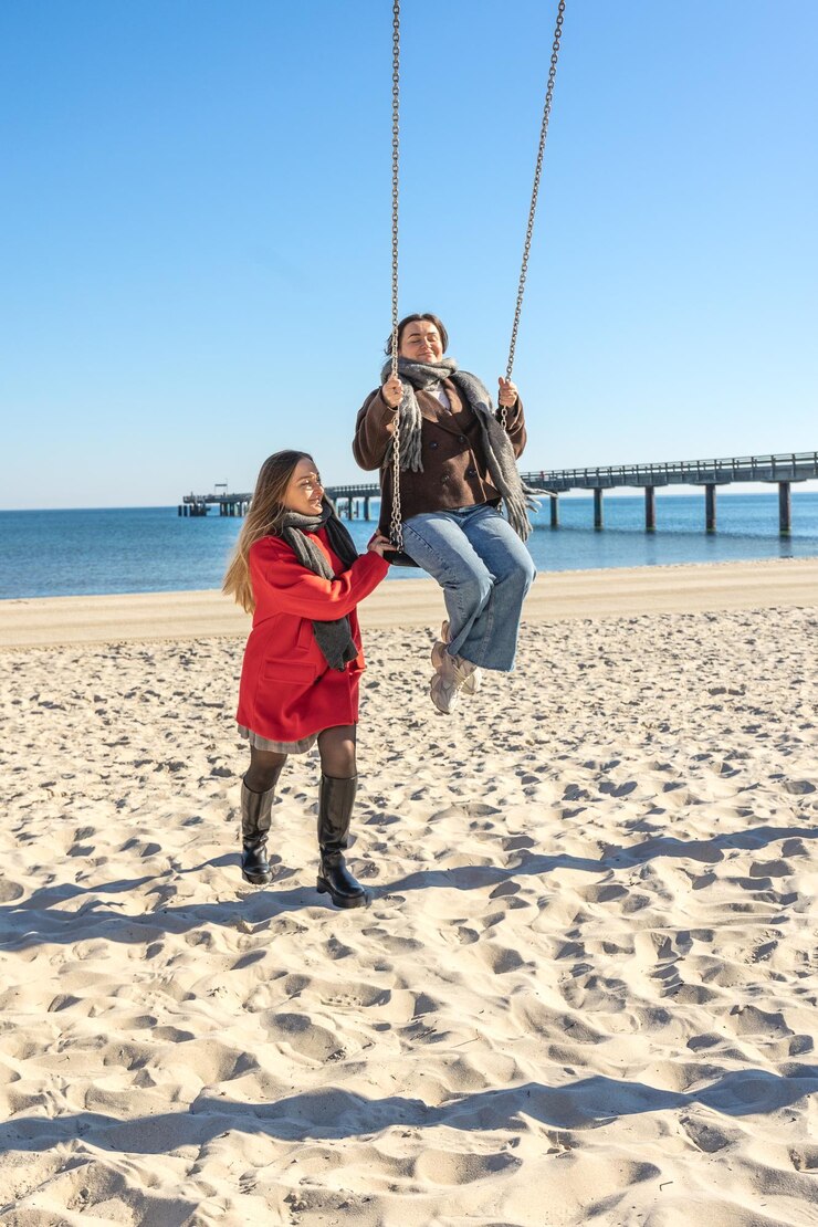 two-women-swinging-swing-beach-sea-beach-vacation-with-friend_169016-67523